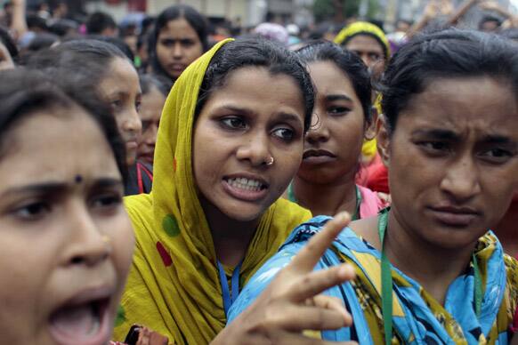 A Bangladeshi woman worker gestures as she along with the others participates in a protest outside a garment factory in Dhaka, Bangladesh.