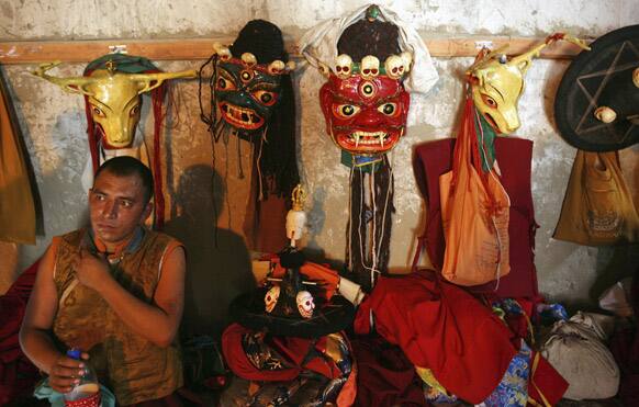 A Buddhist monk rests before his performance during a local festival at the Phyang Monastery on the outskirts of Leh, India.