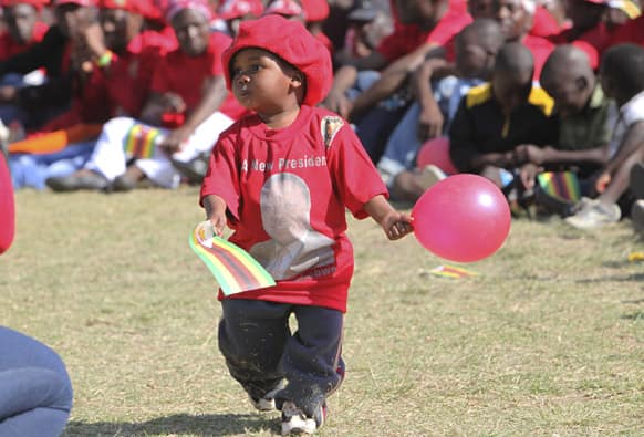 A child holds a balloon and walks around during the launch of the Movement For Democratic Change`s election campaign in Marondera, about 100 kilometres east of Harare.