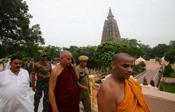 Buddhist monks and security officers walk after an explosion on the campus of the Mahabodhi Temple, the Buddhist Great Awakening temple, in Bodhgaya.