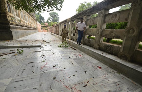 A security officer inspects the site of an explosion as blood lies splattered around the Bodhi tree, under which Buddha is believed to have achieved enlightenment, at the premise of the Mahabodhi Temple.