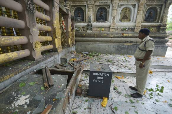 A security officer inspects the site of an explosion on the campus of the Mahabodhi Temple, the Buddhist Great Awakening temple, in Bodhgaya.