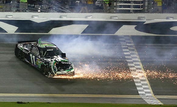 Denny Hamlin slides down the frontstretch after he was involved in a wreck in the NASCAR Sprint Cup auto race at Daytona International Speedway.