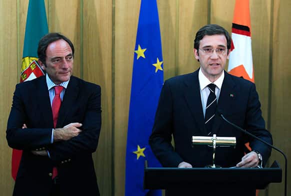 Portugal`s Prime Minister and leader of the Social Democrat Party, PSD, Pedro Passos Coelho, right, gives an statement next to Portugal`s Foreign Minister and leader of Popular Party, CDS, Paulo Portas following their meeting in Lisbon.
