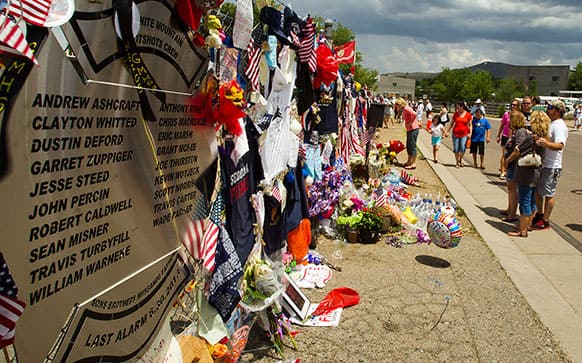 Items are displayed at a makeshift memorial at the Fire Station No. 7 memorial for fallen firefighters in Prescott, Ariz.