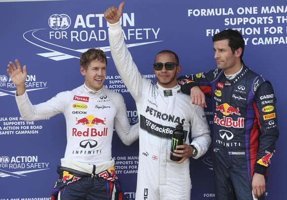 Mercedes driver Lewis Hamilton, pole position, Red Bull driver Sebastian Vettel, second fastest time, and Red Bull driver Mark Webber, third fastest time, pose for media after the qualifying session at the Nuerburgring racetrack, in Nuerburg, Germany.