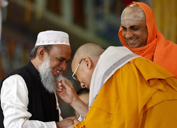 Hindu priest Shivratri Deshikendra, watches Tibetan spiritual leader the Dalai Lama, playfully tug the beard of a Muslim priest Mohammed Usman Shariff during an event organized to celebrate the Dalai Lama`s 78th birthday at a Tibetan Buddhist monastery in Bylakuppe, Bangalore
