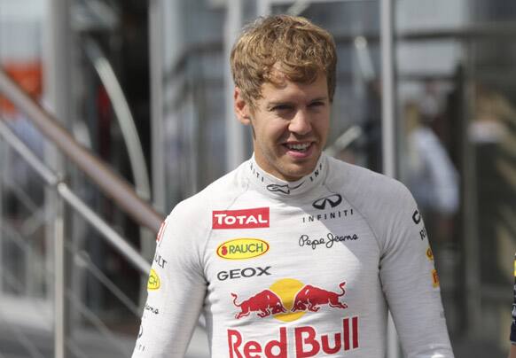 Red Bull driver Sebastian Vettel of Germany walks in the paddock prior to the start of the third free practice at the Nuerburgring racetrack, in Nuerburg.