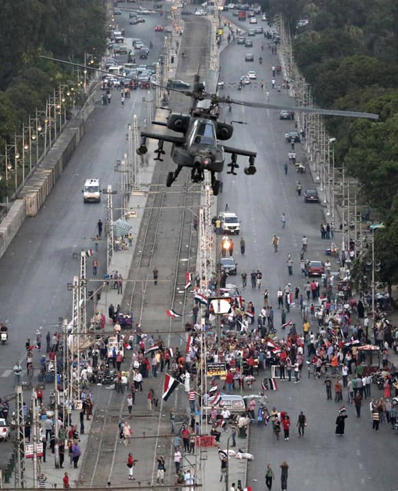 A military attack helicopter flies over a street near the presidential palace, in Cairo, Egypt.