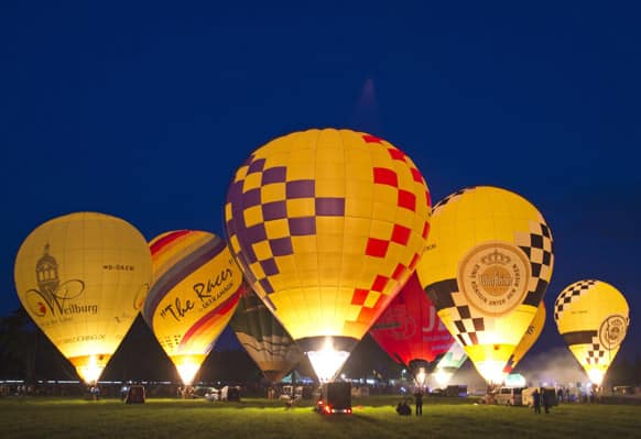 Hot air balloons glow in the evening light during the international balloon festival `Montgolfiade` in Heldburg, central Germany.