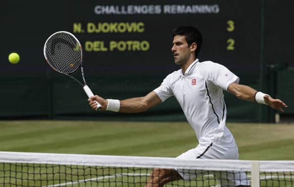 Novak Djokovic of Serbia returns to Juan Martin Del Potro of Argentina during the Men`s singles semifinal match at the All England Lawn Tennis Championships in Wimbledon.