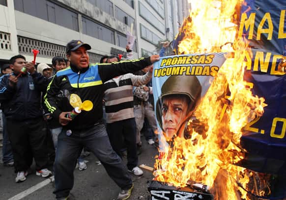 A construction worker burns a poster with the image of Peru`s President Ollanta Humala, during a protest against a new civil service law that will require public sector employees to undergo work evaluations periodically, in Lima, Peru.