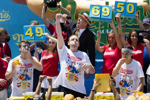Joey Chestnut, center, wins the Nathan`s Famous Fourth of July International Hot Dog Eating contest with a total of 69 hot dogs and buns, alongside Tim Janus, left, and Matt Stonie, at Coney Island, in the Brooklyn borough of New York.