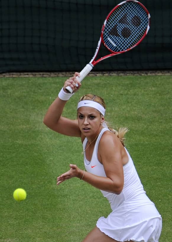 Sabine Lisicki of Germany returns to Agnieszka Radwanska of Poland during their Women`s singles semifinal match at the All England Lawn Tennis Championships in Wimbledon.