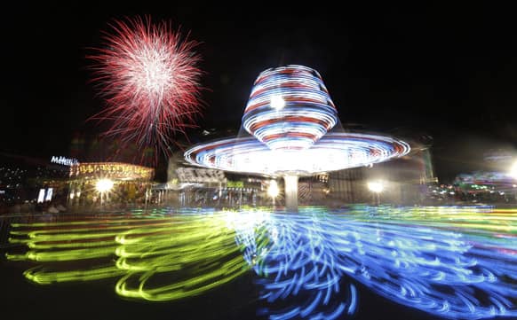 Fireworks explode over the Sizzler carnival ride at State Fair Meadowlands in East Rutherford, N.J.