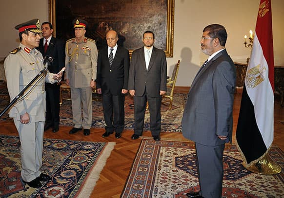 FILE - File photo, Egyptian President Mohammed Morsi swears in newly-appointed Minister of Defense, Lt. Gen. Abdel-Fattah el-Sissi, in Cairo, Egypt. A statement on the Egyptian president`s office`s Twitter account has quoted Mohammed Morsi as calling military measures