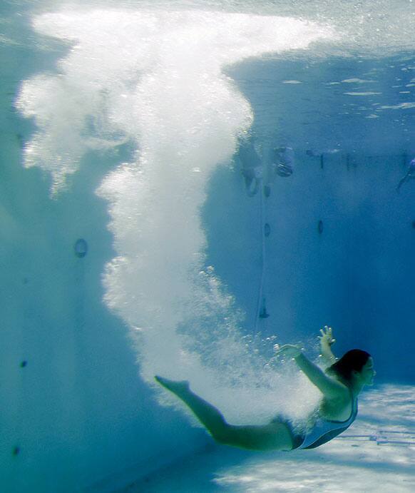Hannah Tiendas, a member of the Santa Clara diving team, leaves a bubble trail as she goes underwater during practice at the Santa Clara international swim center in Santa Clara , Calif.