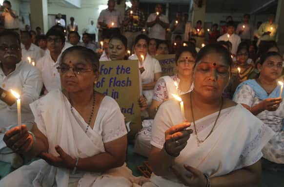 People hold candles as they pray for the victims of Uttarakhand floods, at a temple in Ahmadabad.