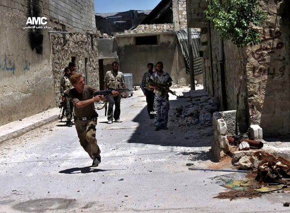A Syrian rebel fires his weapon during heavy clashes with Syrian soldiers loyal to Syrian President Bashar Assad near Aleppo International Airport in Aleppo, Syria.