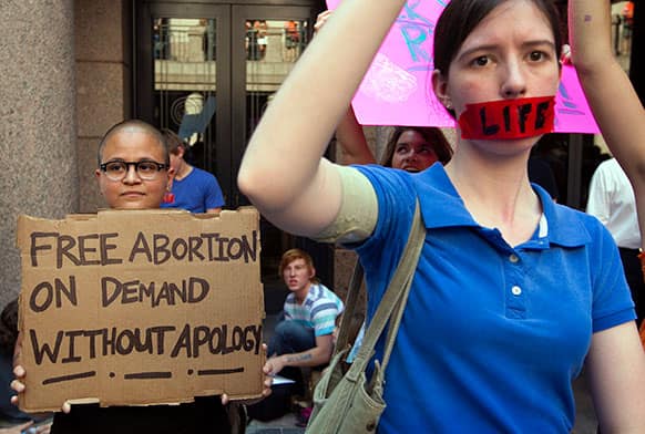 Pro-abortion rights supporter Yatzel Sabat, left, and anti-abortion protestor Amanda Reed demonstrate at the state Capitol in Austin, Texas.