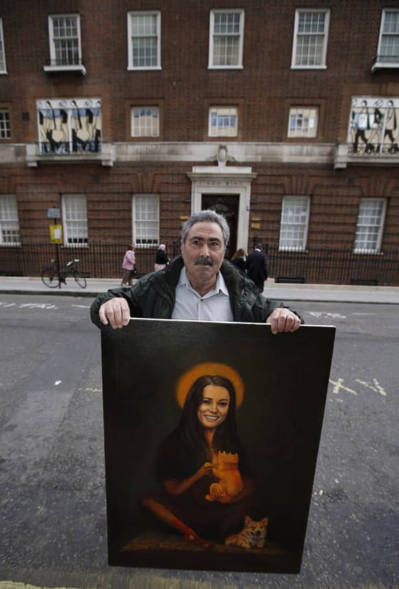 Political painter Kaya Mar, 56, poses with his latest painting depicting Britain`s Kate Duchess of Cambridge with a halo and holding a baby, across the street from St. Mary`s Hospital exclusive Lindo Wing in London.