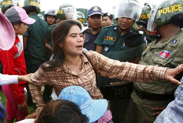 Tep Vanny of Boeung Kak lake is blocked by riot police officers during a protest rally near the prime minister`s residence in Phnom Penh, Cambodia.