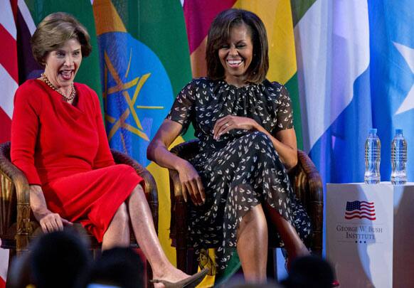 US first lady Michelle Obama and former US first lady Laura Bush laugh as they participate in the African First Ladies Summit: “Investing in Women: Strengthening Africa,” hosted by the George W. Bush Institute, in Dar es Salaam, Tanzania.