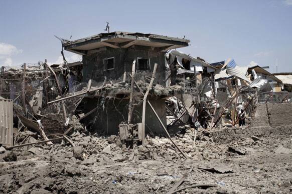 Afghan security forces officer stands guard the gate to a NATO compound following a suicide car bombing in Kabul.