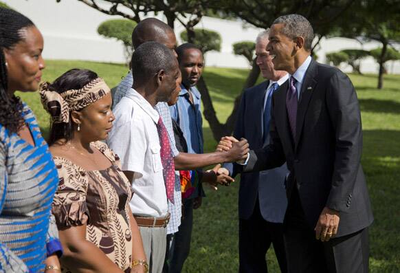 US President Barack Obama, right, and former President George W. Bush shake hands with family members of victims of the US Embassy bombing during a wreath laying ceremony at the US Embassy.