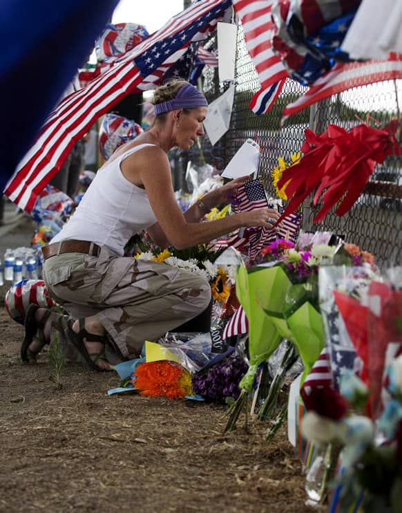 Wendy Tollefsen sets down flowers and flags at a makeshift memorial outside the Granite Mountain Interagency Hotshot Crew fire station, in Prescott, Ariz.