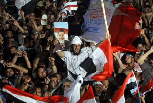 Supporters of Egypt`s Islamist President Mohammed Morsi wave his pictures and national flags during a rally in Nasser City, in Cairo.