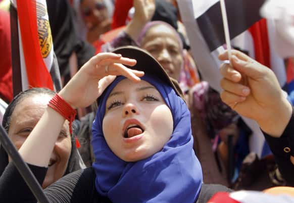 An Egyptian protester ululates and waves a national flag during a demonstration against Egypt`s Islamist President Mohammed Morsi in Tahrir Square in Cairo.