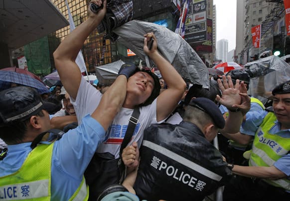 Protesters scuffle with police officers on a downtown street during an annual pro-democracy protest in Hong Kong.