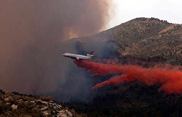 Tanker 910 makes a retardant drop on the Yarnell Hill Fire to help protect the Double Bar A Ranch near Peeples Valley, Arizona.