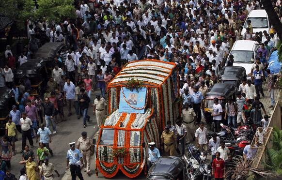 People gather to pay respect to Wing Cmdr. of Indian Air Force (IAF) Darryl Castelino, a victim of a helicopter that crashed during a rescue mission in flood-ravaged northern India, during his funeral procession in Mumbai.