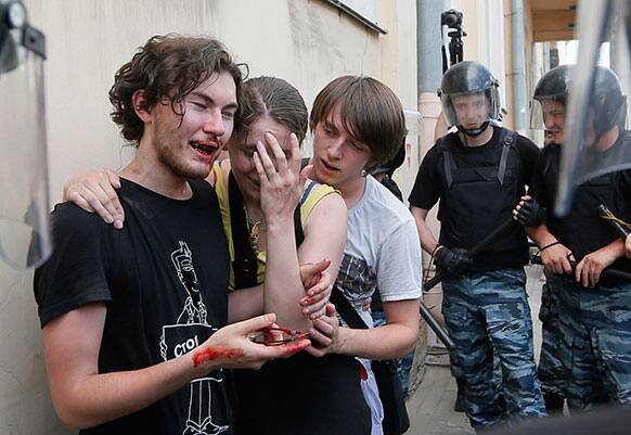 Riot police (OMON) guard gay rights activists who have been beaten by anti-gay protesters during an authorized gay rights rally in St.Petersburg, Russia.