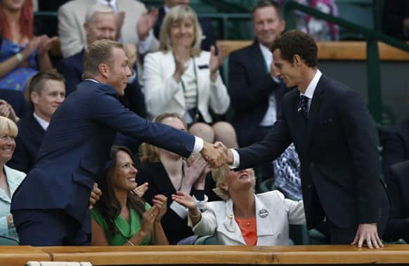Olympic gold medal winning cyclist Sir Chris Hoy shakes hands with tennis player Andy Murray of Britain as they take their seats on Centre Court at the All England Lawn Tennis Championships in Wimbledon, London.