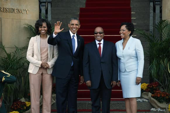 US President Barack Obama flanked by First Lady Michelle Obama, waves with South African President Jacob Zuma and his wife Tobeka Madiba Zuma, on the steps of Union Building in Pretoria, South Africa.