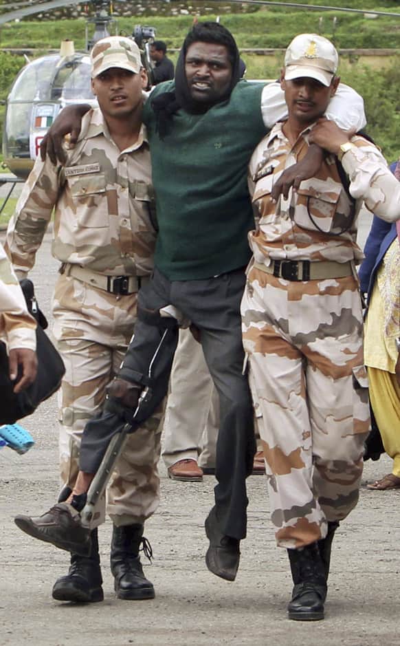 Paramilitary soldiers carry a pilgrim towards the airport in Gaucher, in the northern Indian state of Uttarakhand.
