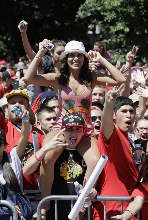 Fans cheer along the parade route as buses carrying the Stanley Cup champion Chicago Blackhawks passes in Chicago.