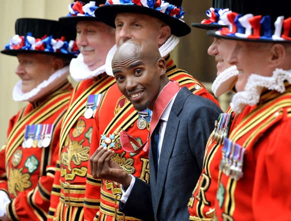 Double Olympic gold medallist athlete Mo Farah smiles with his CBE medal after receiving the award from Britian`s Prince Charles at Buckingham Palace in central London.