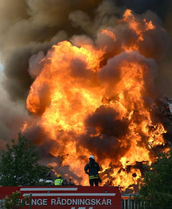 Firefighters battle a fire in a junk yard in Malmo, southern Sweden. Firefighters say plastic and rubber materials are burning forcefully, sending a toxic plume into the sky, but the winds are blowing the smoke toward the Oresund strait, and no residential areas are at risk.