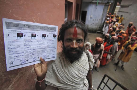 A Hindu holy man displays his registration permit as others wait to register for the annual pilgrimage to the Amarnath cave shrine in Jammu.