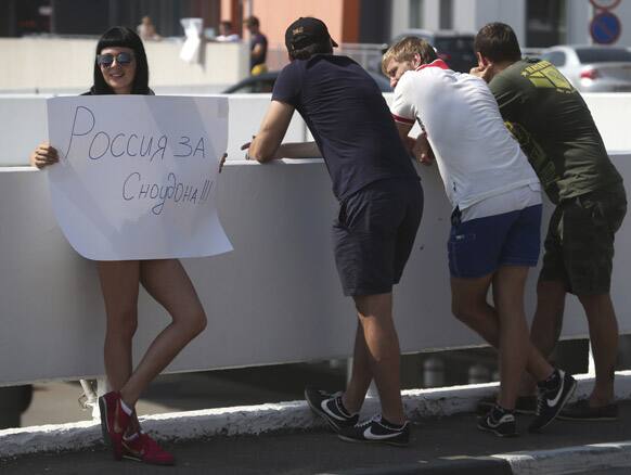 A protester holds a poster outside Sheremetyevo, airport in Moscow. Russian and foreign journalists continued to monitor the Sheremetyevo international airport, where National Security Agency leaker Edward Snowden is believed to remain at the transit zone. The poster reads :