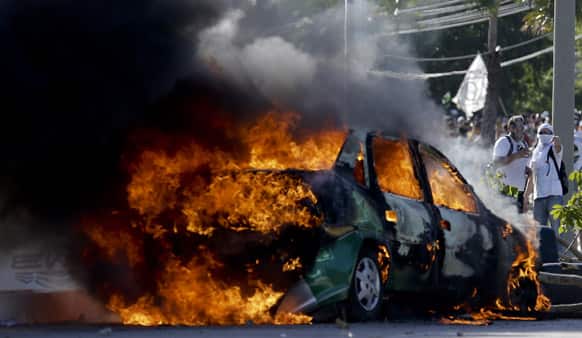 A car goes up in flames as protesters clashed with police near the soccer stadium where Spain and Italy met in a Confederations Cup soccer semifinals` match in Fortaleza, Brazil.