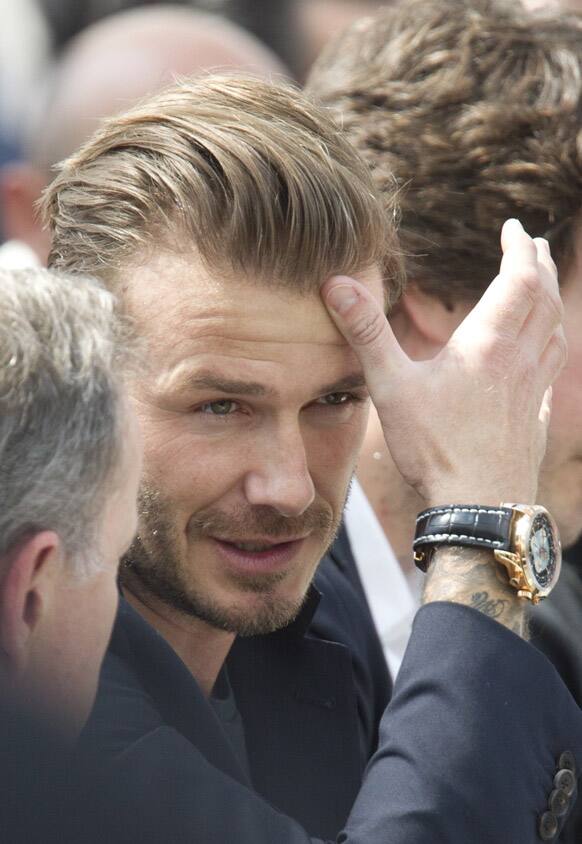 Former British soccer star David Beckham gestures during Vuitton`s Spring-Summer 2014 men`s collection presented in Paris.