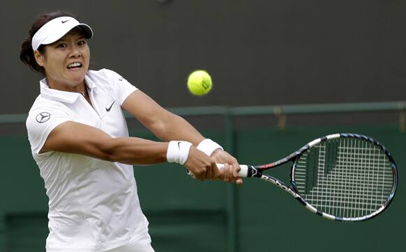 Li Na of China returns to Simona Halep of Romania during their Women`s second round singles match at the All England Lawn Tennis Championships in Wimbledon, London.