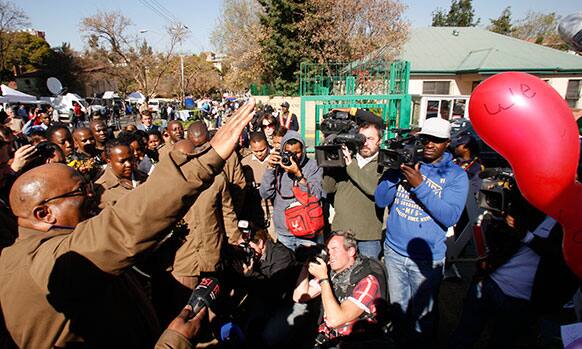 A correctional services officer prays outside the Mediclinic Heart Hospital where former South African President Nelson Mandela is being treated in Pretoria, South Africa.