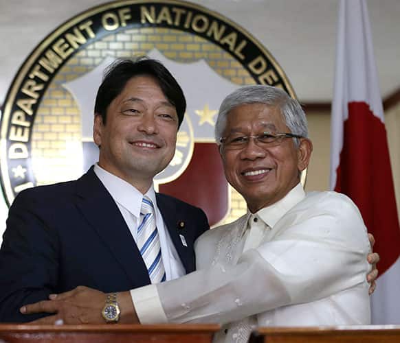Japanese Defense Minister Itsunori Onodera, left, and his Philippine counterpart Voltaire Gazmin pose for photographers following their joint news conference at Camp Aguinaldo at suburban Quezon city, northeast of Manila, Philippines.
