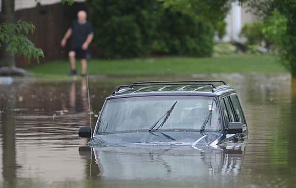 A car is submerged under water along Bristol Trail Road in Lake Zurich, Ill. Wednesday, June 26, 2013 morning after heavy rains hit the area.